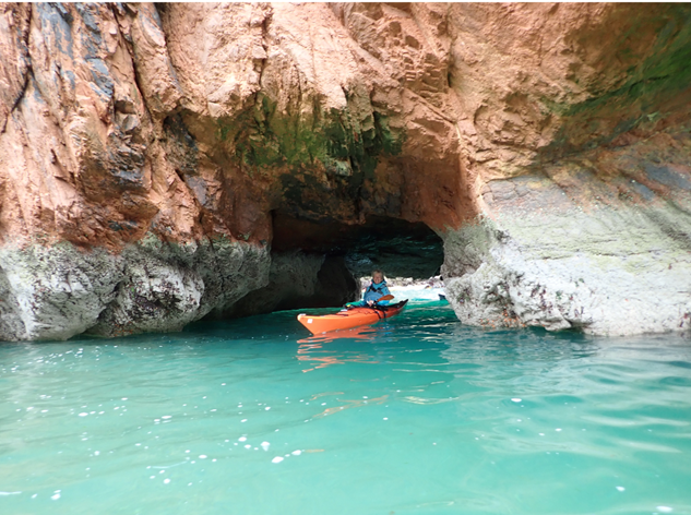 A person in a kayak in a body of water by a rock wall

Description automatically generated with low confidence