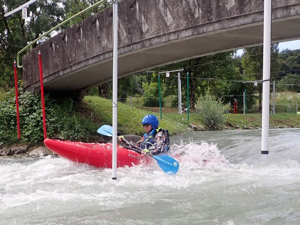 A person in a kayak under a bridge
Description automatically generated