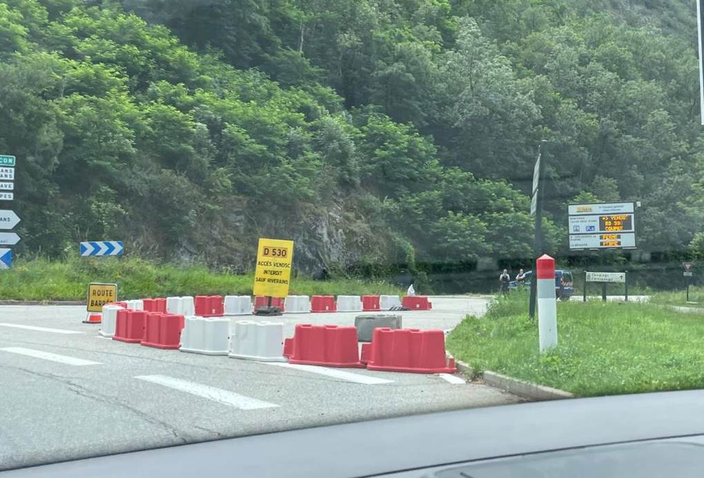 A road with red and white barriers
Description automatically generated