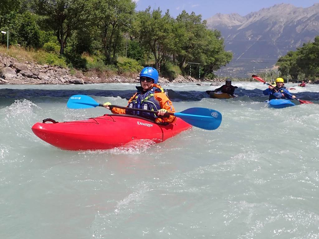 A group of people in kayaks in a river
Description automatically generated