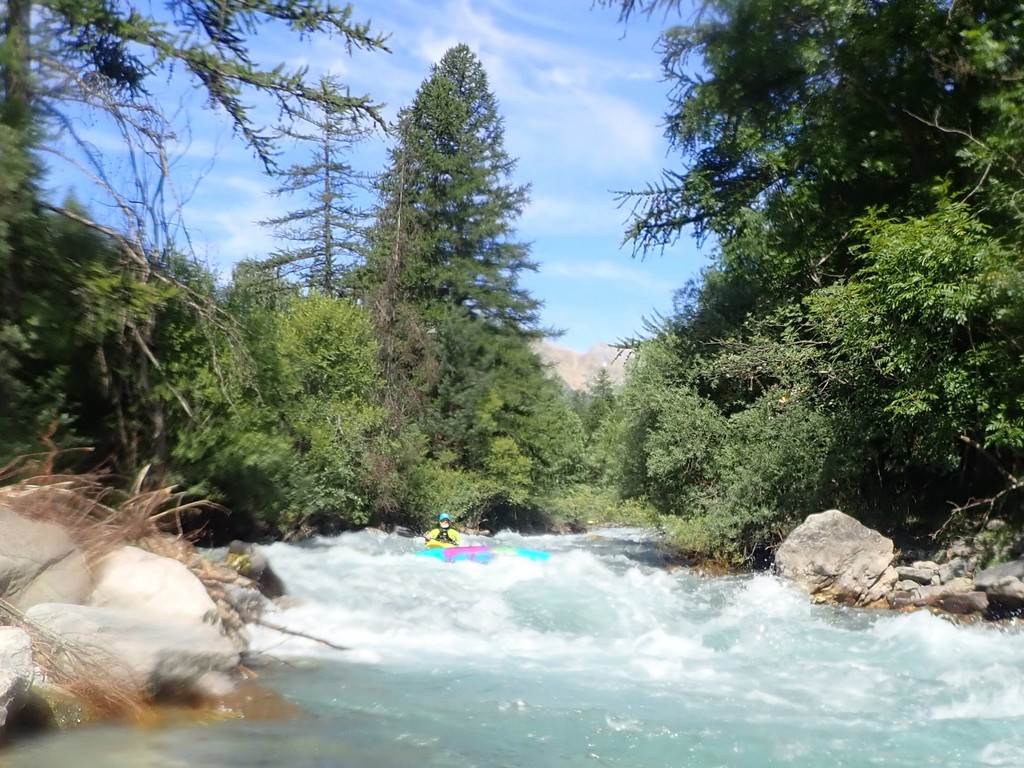 A person in a kayak in a river
Description automatically generated