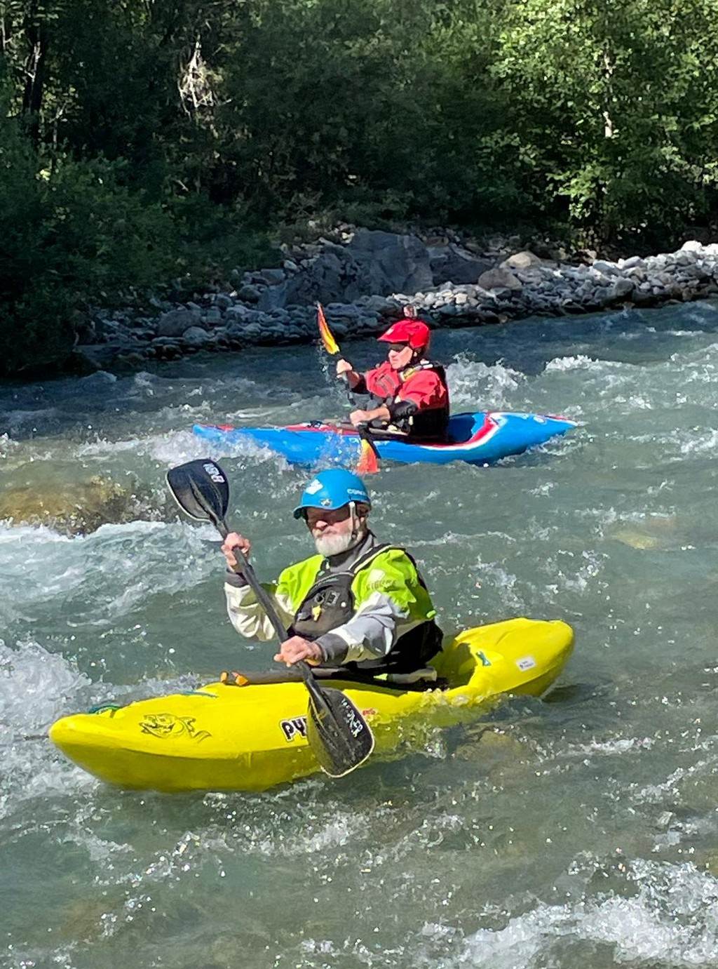 A group of people in kayaks on a river
Description automatically generated