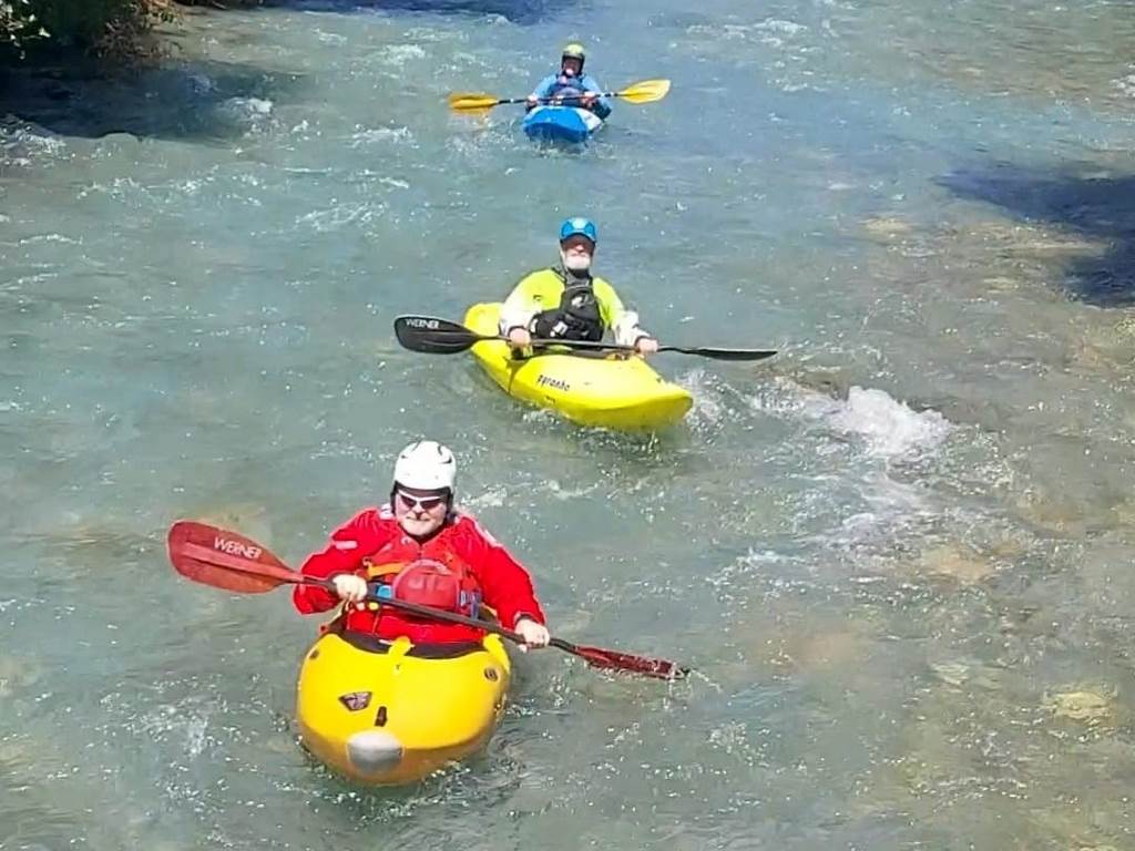 A group of people in kayaks in a river
Description automatically generated