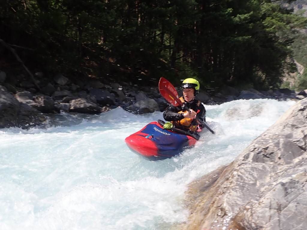 A person in a kayak on a river
Description automatically generated