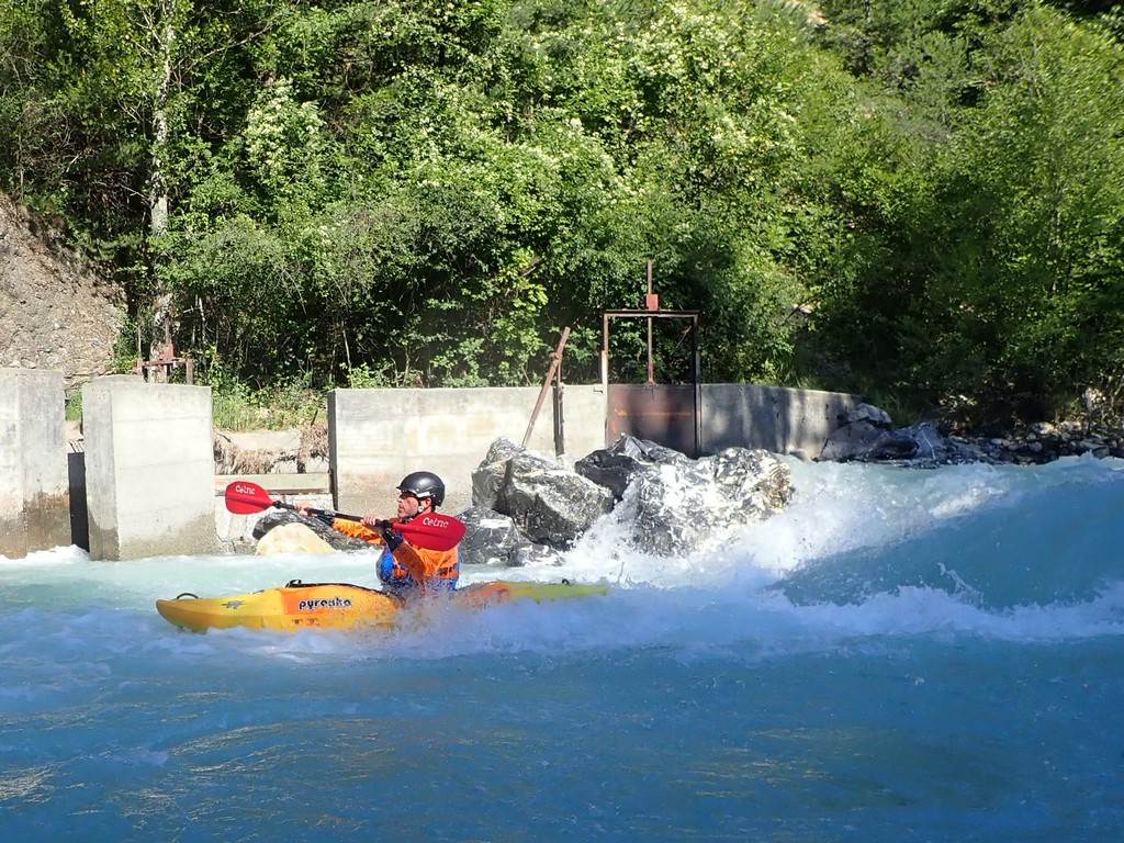 A person in a kayak on a river
Description automatically generated