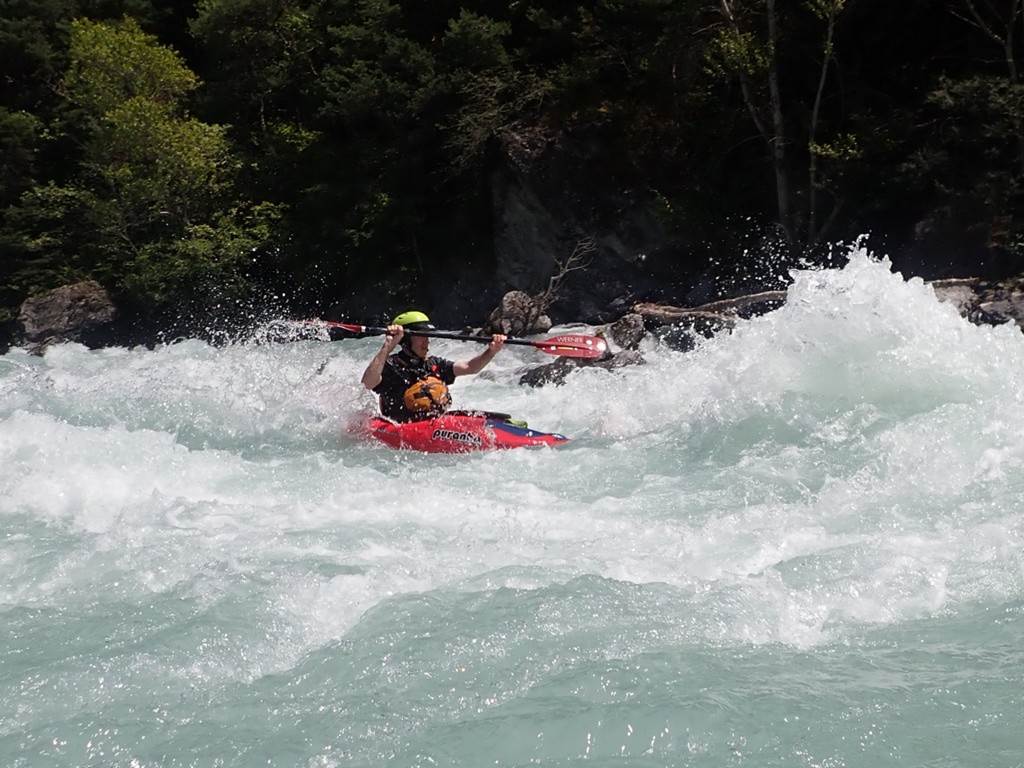 A person in a kayak in a river
Description automatically generated