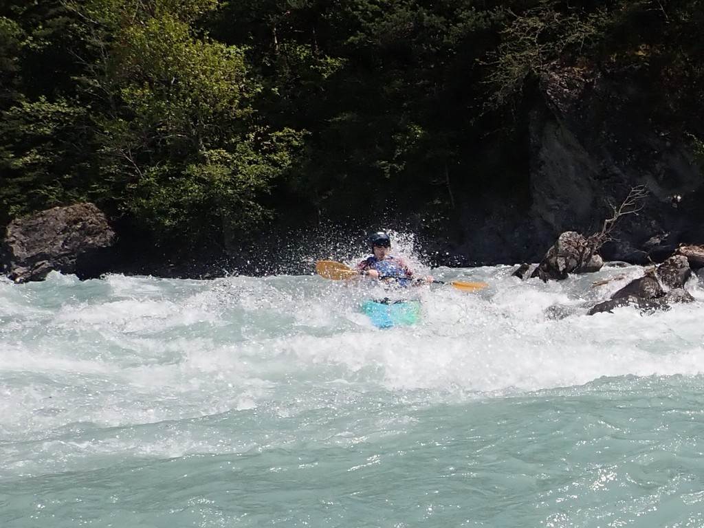 A person in a kayak in a river
Description automatically generated