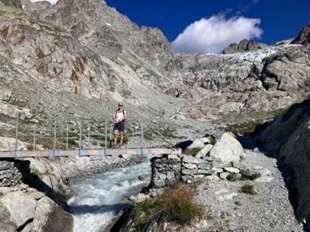 A person standing on a bridge over a river

Description automatically generated