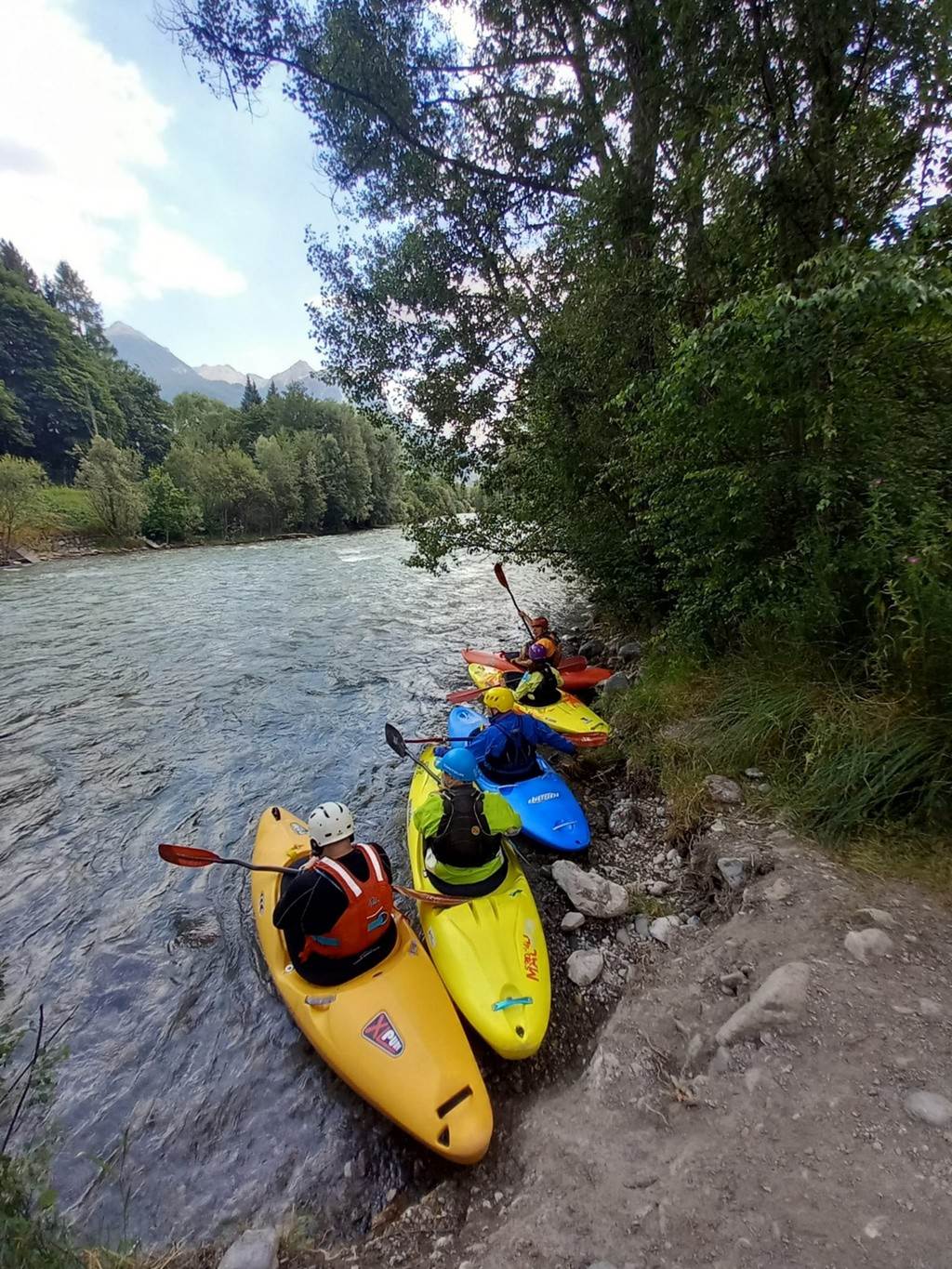 A group of people in kayaks on a river
Description automatically generated
