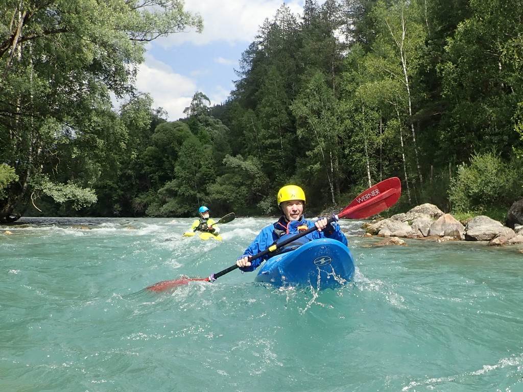 A group of people kayaking in a river
Description automatically generated