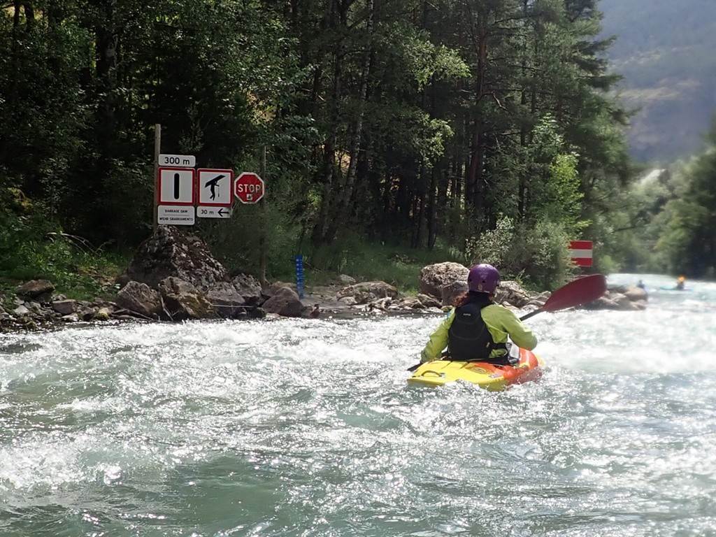 A person in a kayak on a river
Description automatically generated