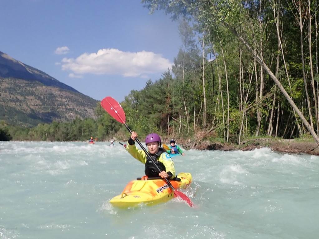 A person in a kayak on a river
Description automatically generated