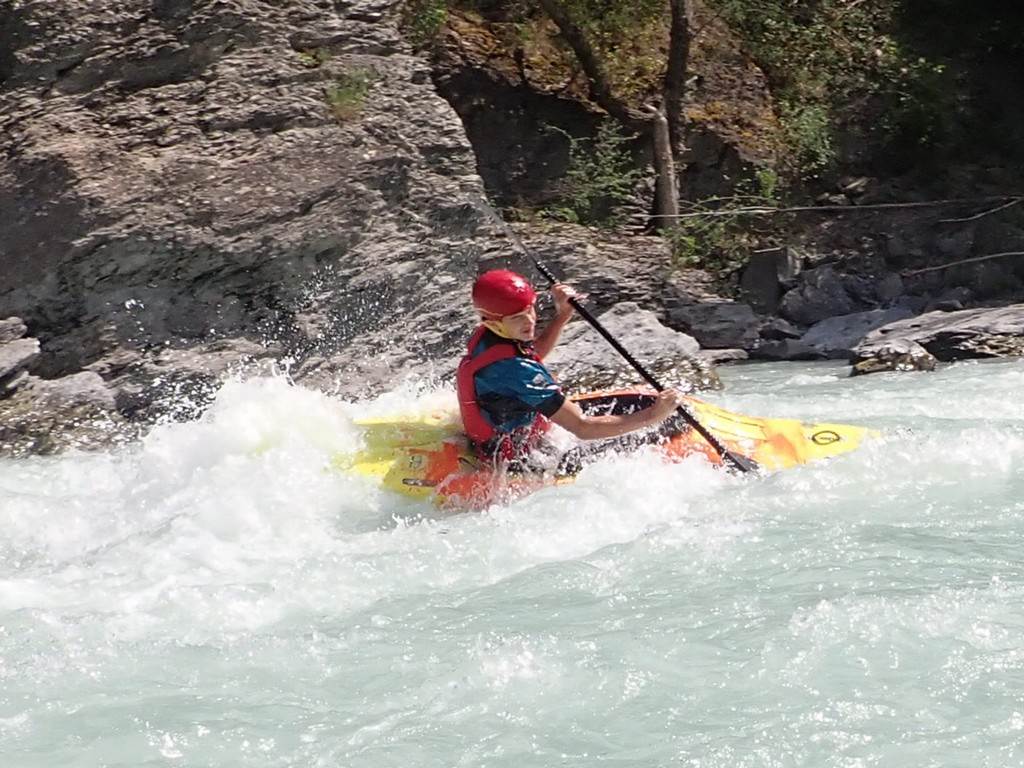 A person in a kayak on a river
Description automatically generated