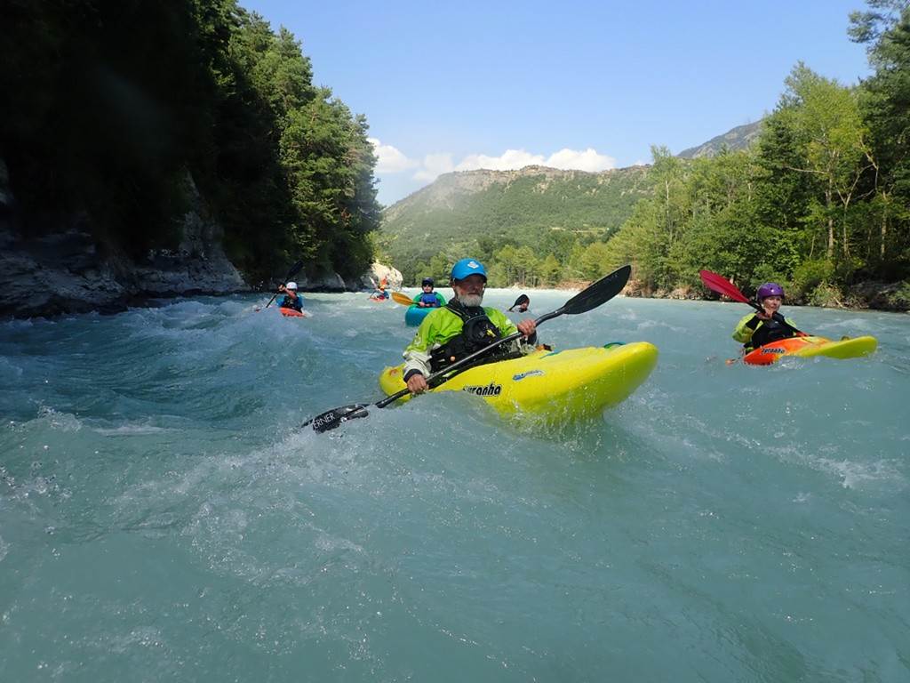 A group of people in kayaks in a river
Description automatically generated