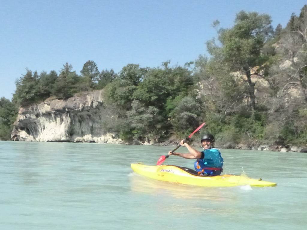 A person in a kayak on a river
Description automatically generated