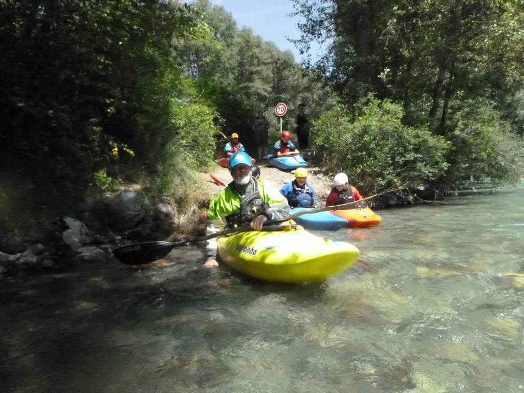 A group of people in kayaks on a river
Description automatically generated