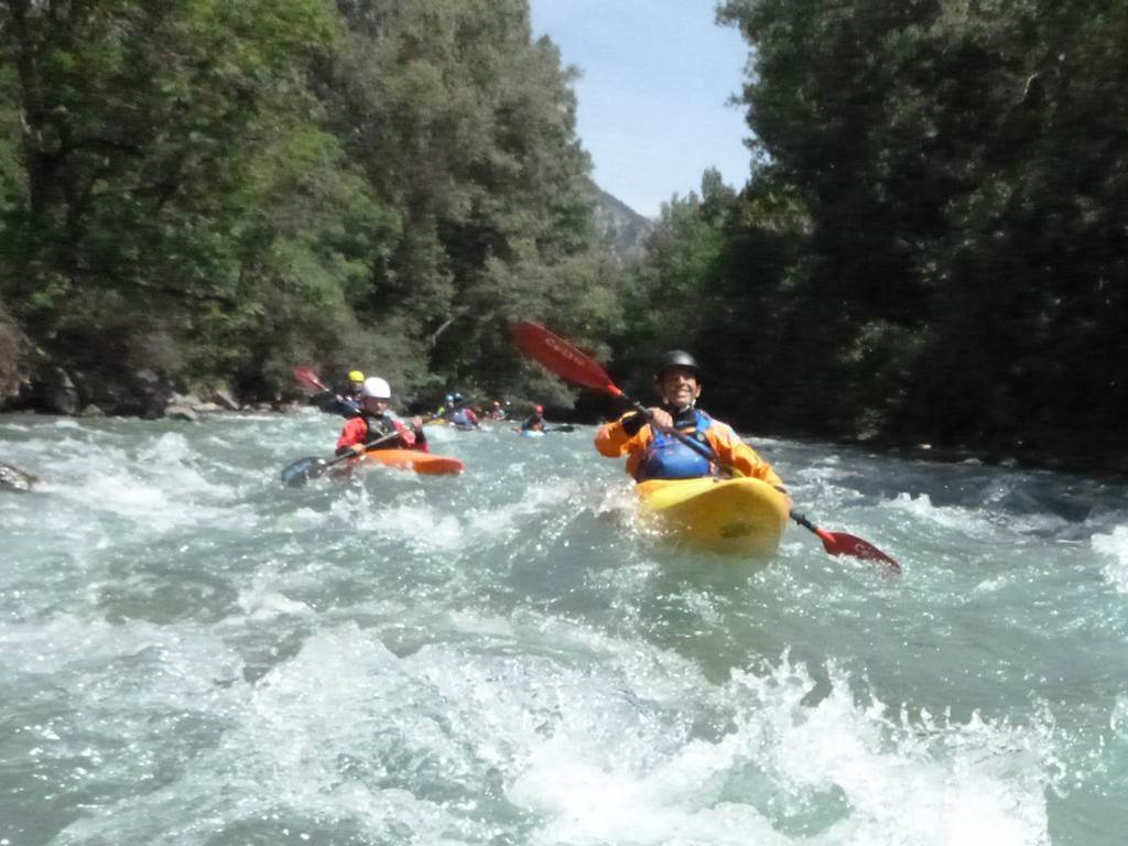 A group of people kayaking in a river
Description automatically generated