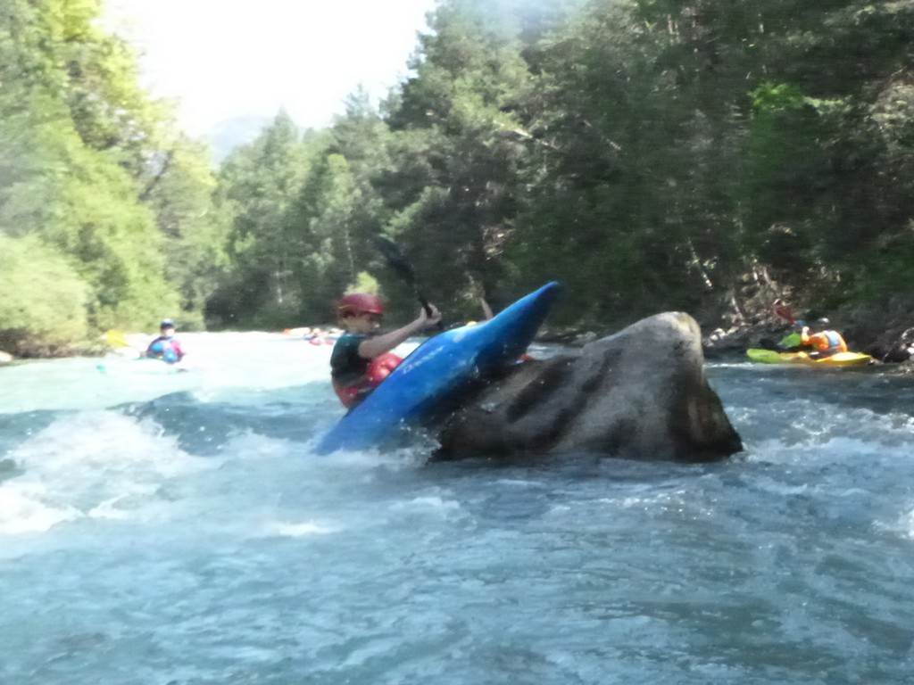A person in a kayak on a rock
Description automatically generated