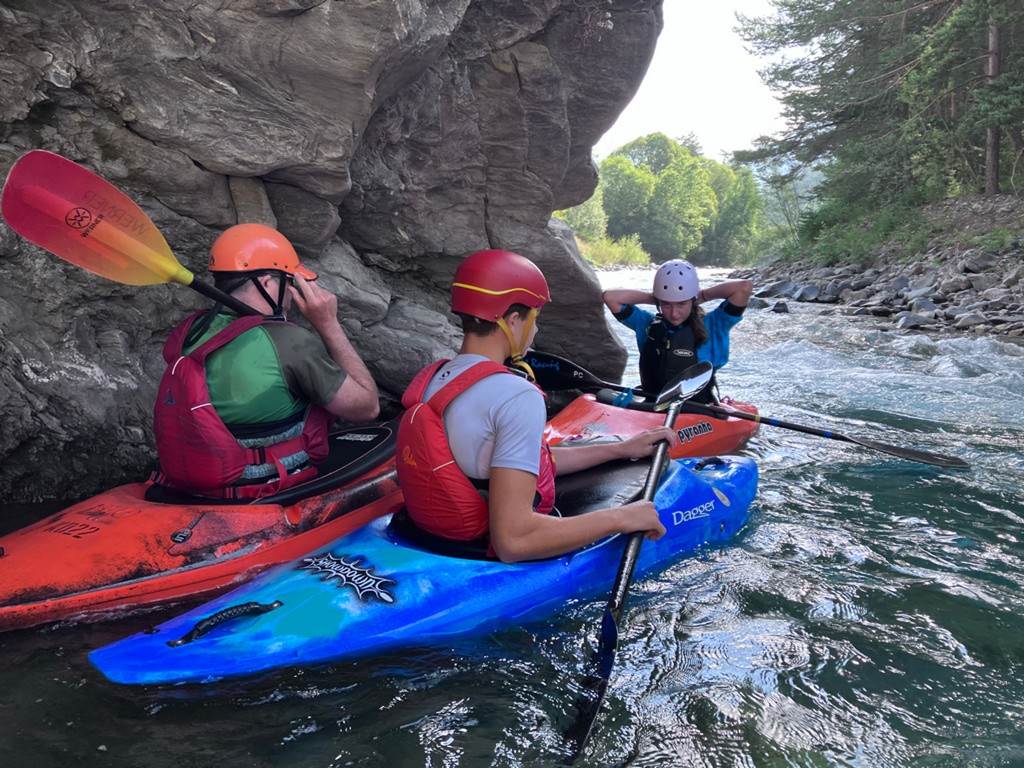 A group of people in kayaks on a river
Description automatically generated