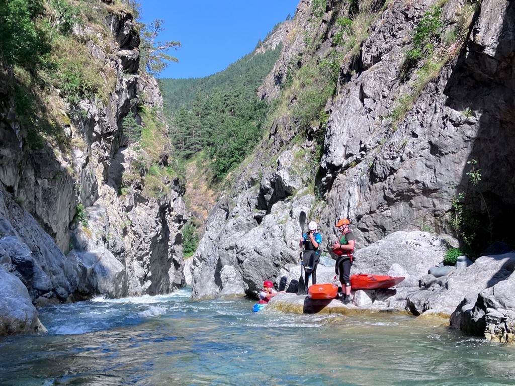 People kayaking in a canyon
Description automatically generated