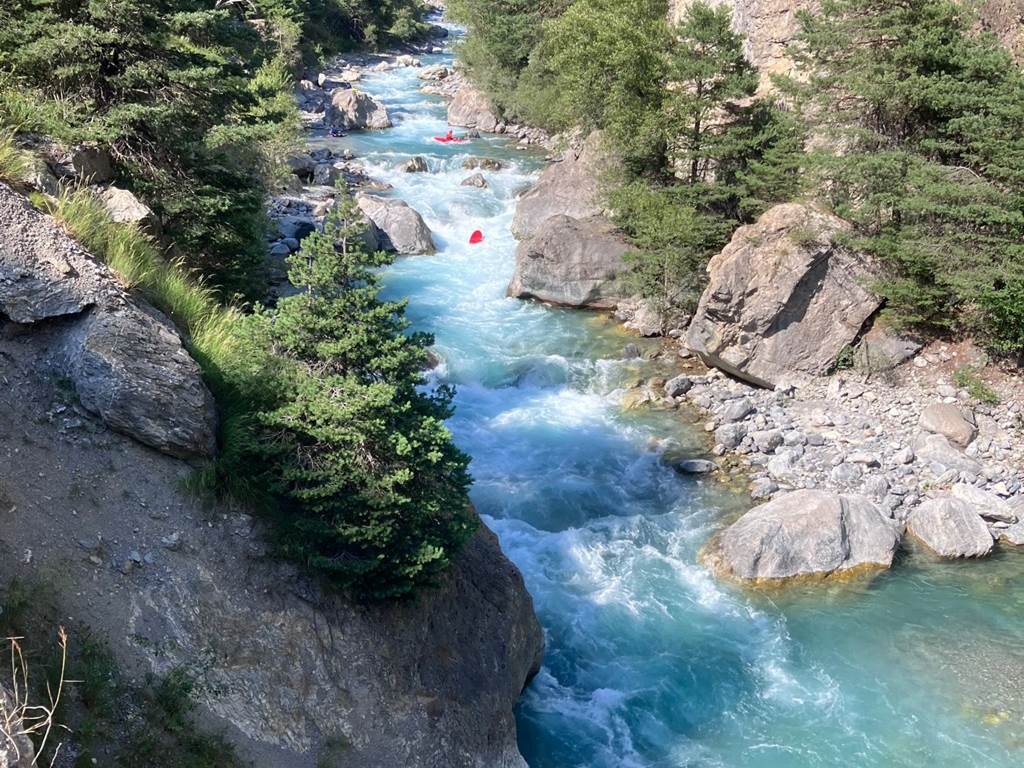 A river running through a rocky canyon
Description automatically generated