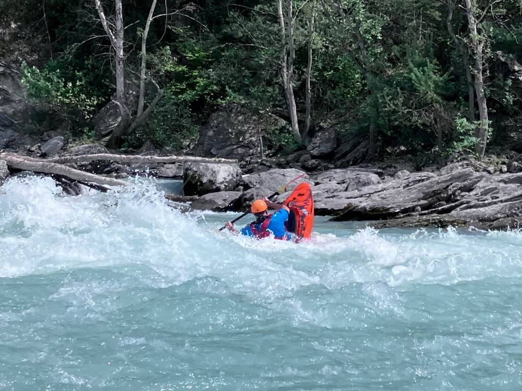 A person in a kayak in a river
Description automatically generated