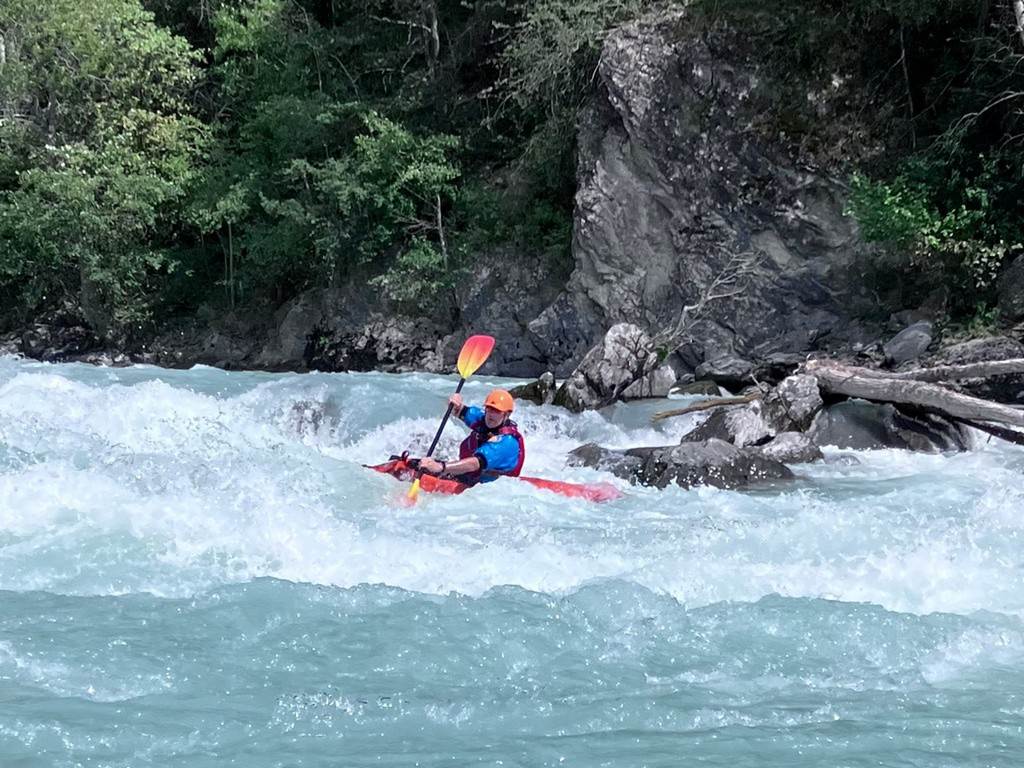 A person in a kayak on a river
Description automatically generated