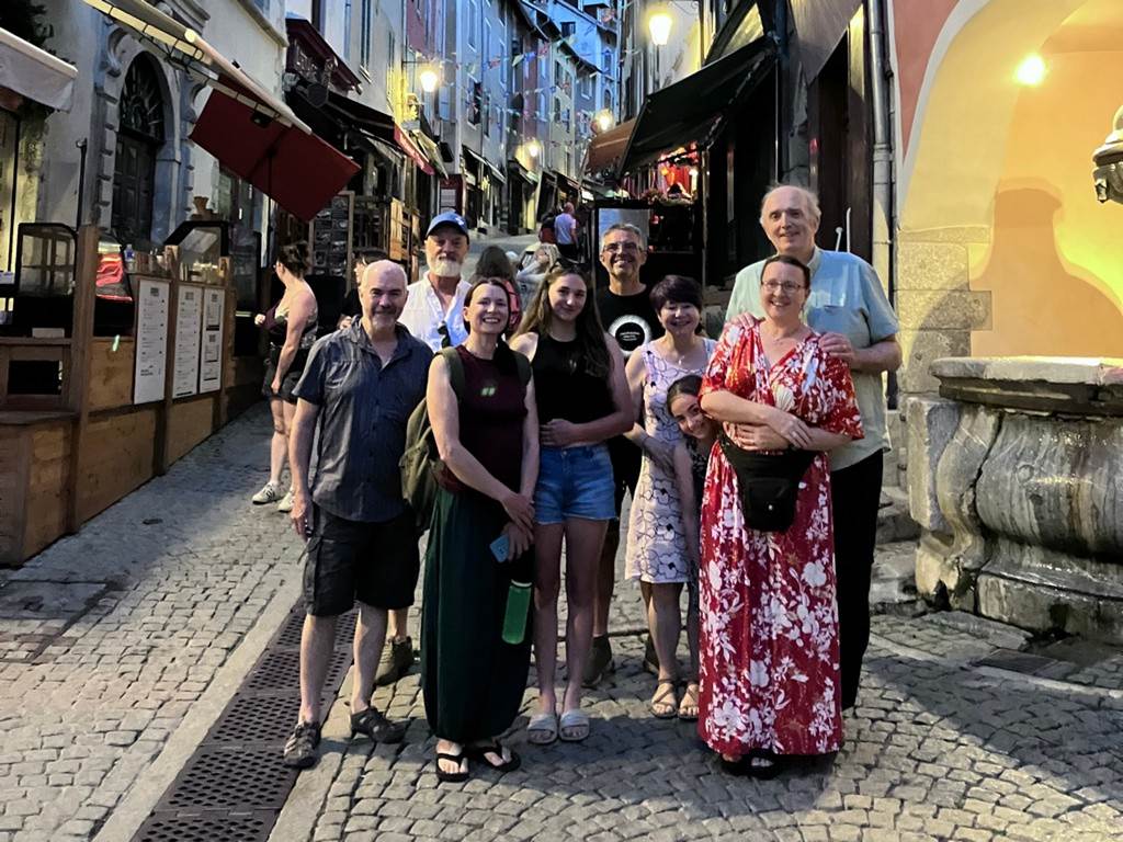 A group of people standing on a cobblestone street
Description automatically generated