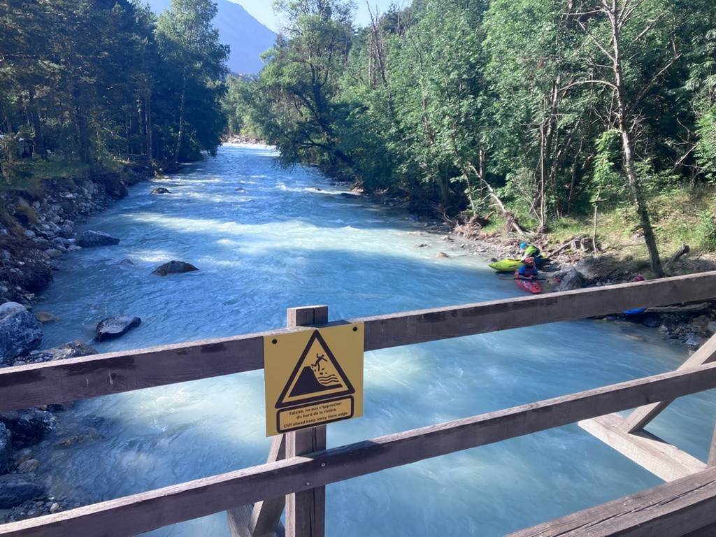 A river with a sign on it
Description automatically generated