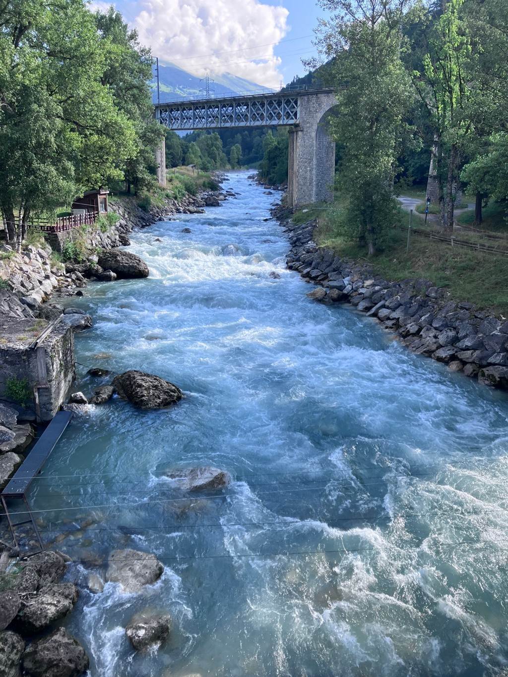 A river with a bridge over it
Description automatically generated