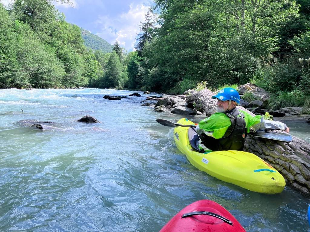 A person in a kayak on a river
Description automatically generated