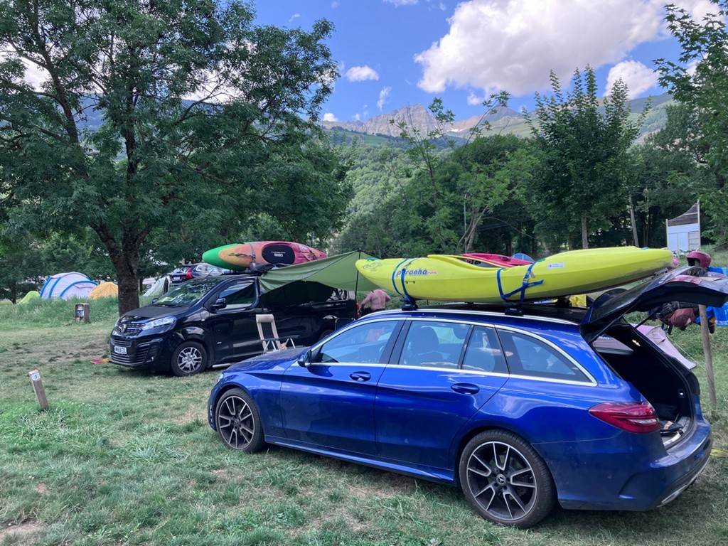 A car with kayaks on top of it
Description automatically generated