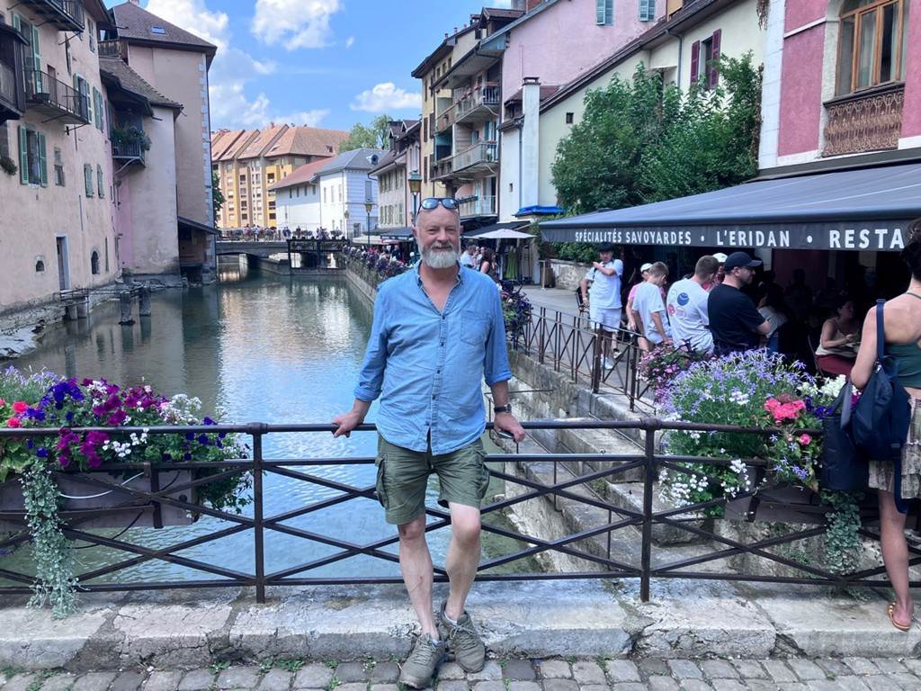 A person standing on a bridge over a river
Description automatically generated