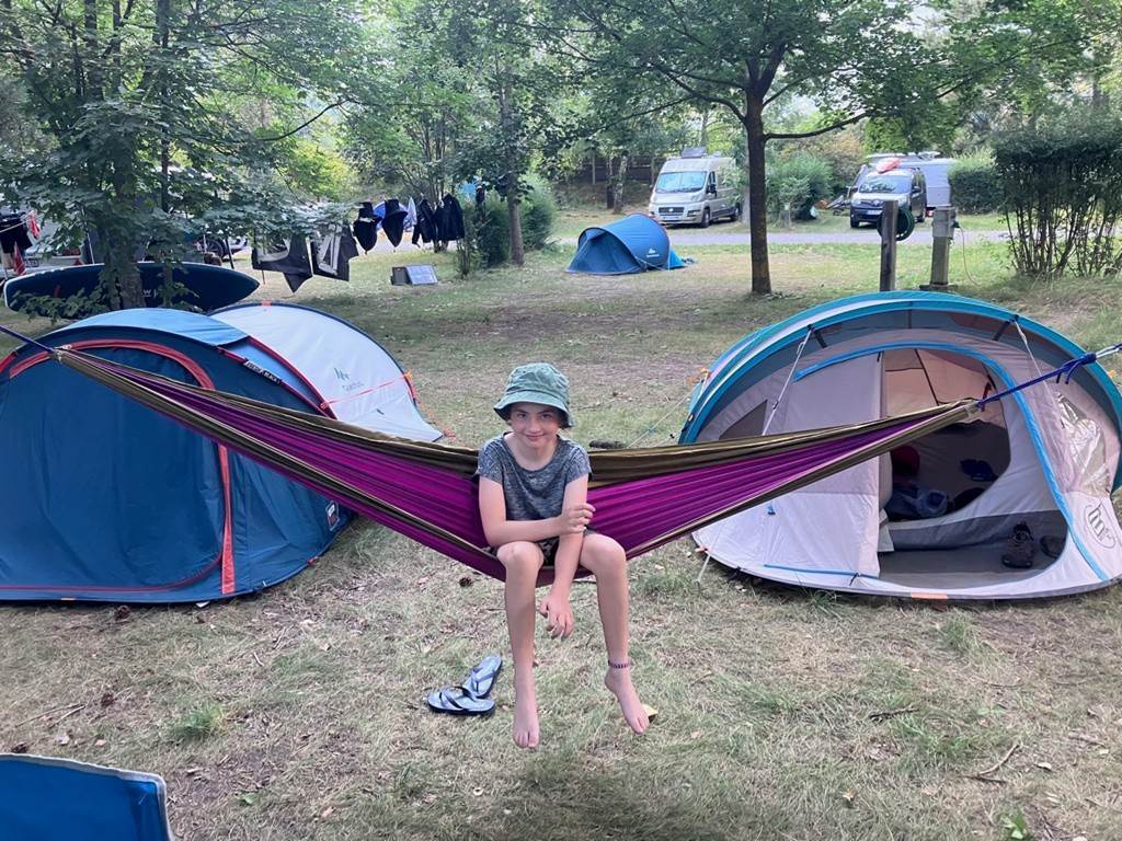 A child sitting in a hammock
Description automatically generated