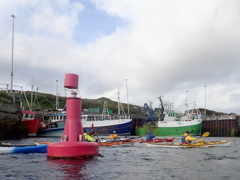 Boats in the water with boats and a buoy

Description automatically generated