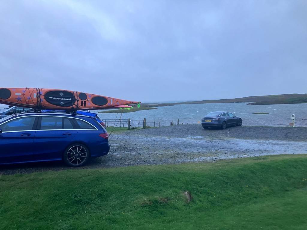A car with a kayak on top of it

Description automatically generated