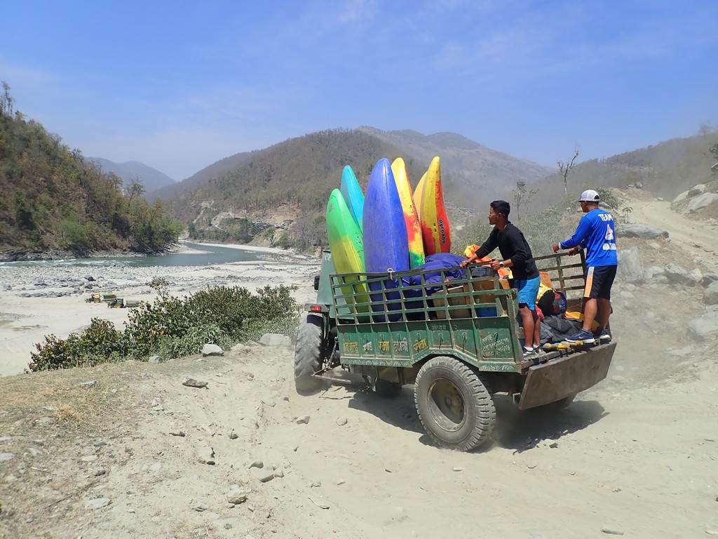 A group of people carrying surfboards on a truck

Description automatically generated