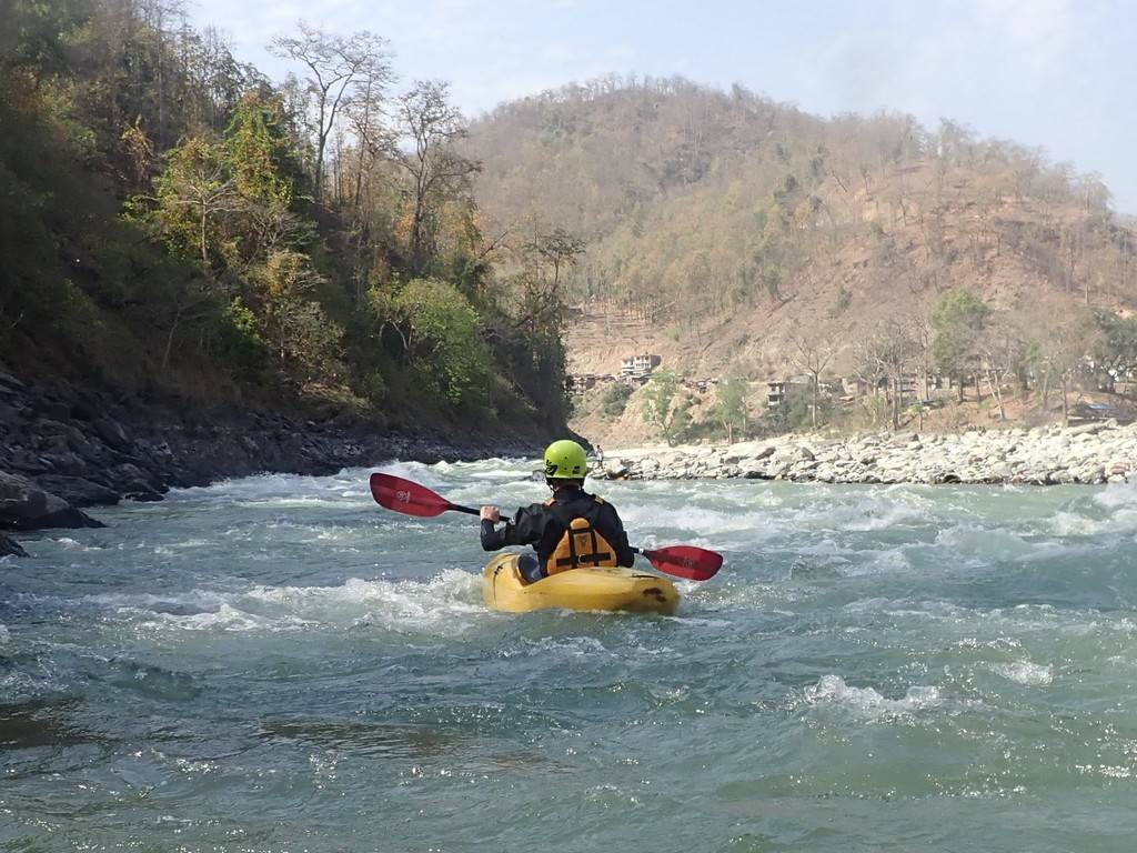 A person in a kayak on a river

Description automatically generated