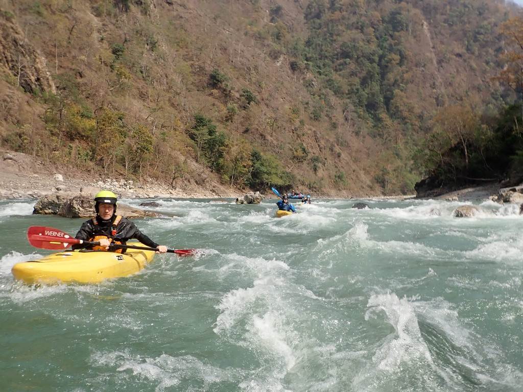 A group of people kayaking in a river

Description automatically generated