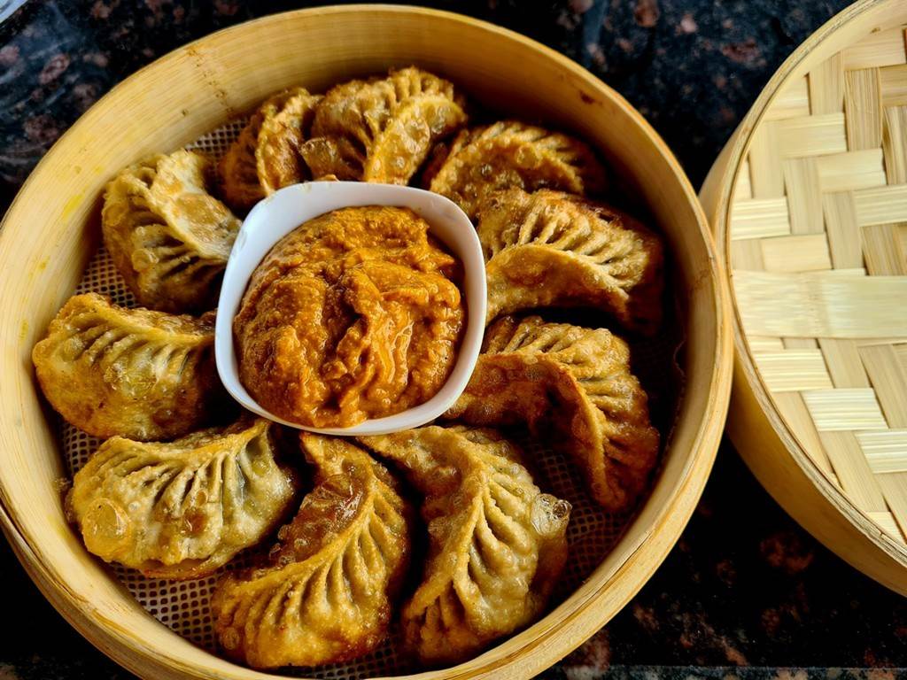 A bowl of food with a sauce in it

Description automatically generated