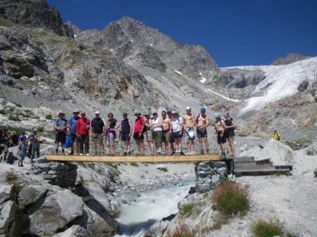A group of people standing on a bridge over a river

Description automatically generated