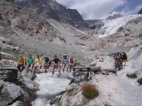 A group of people sitting on a bridge

Description automatically generated