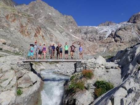 A group of people standing on a bridge over a river

Description automatically generated